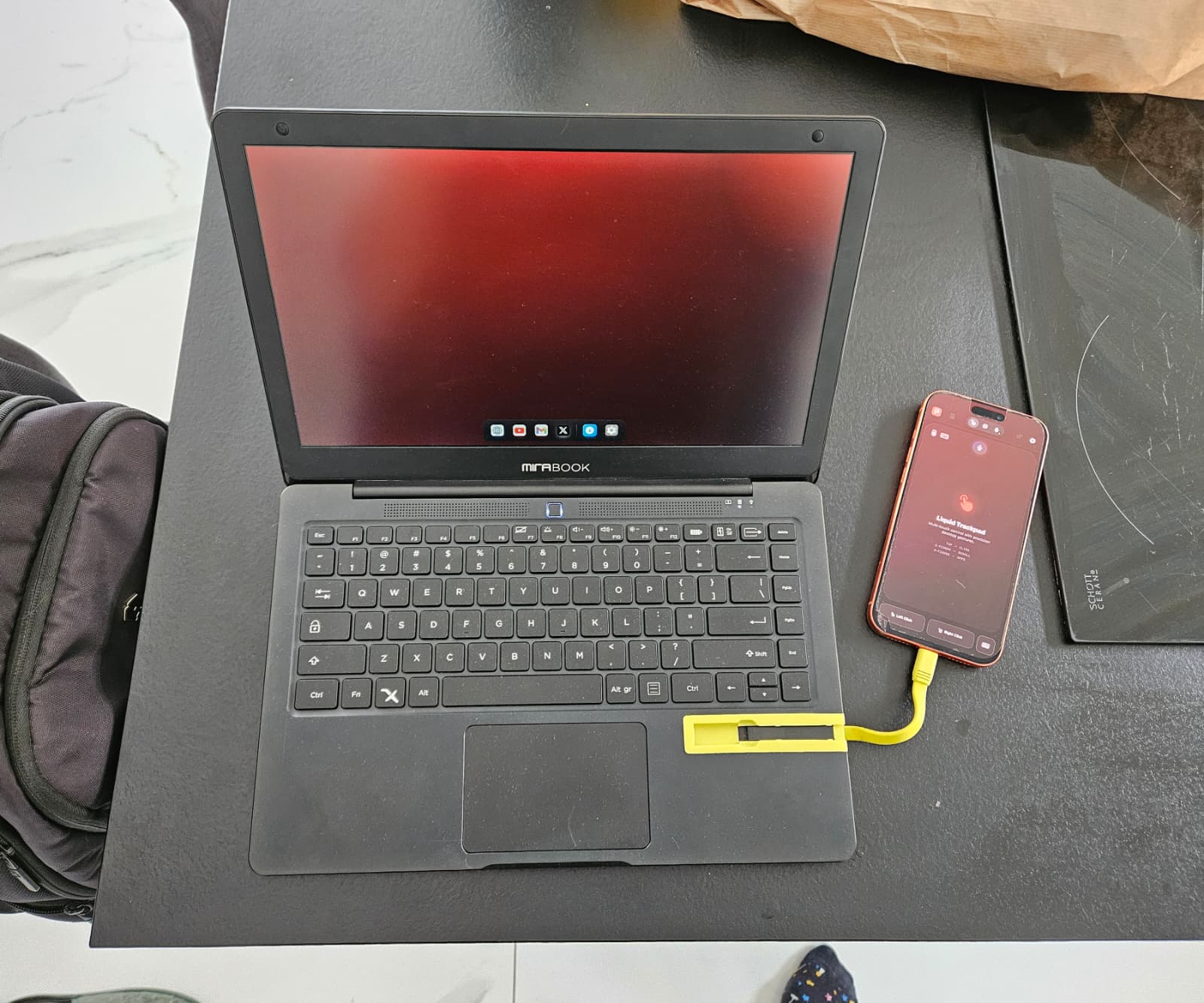 iPhone running Prodoktive connected to a MiraBook lapdock over USB-C